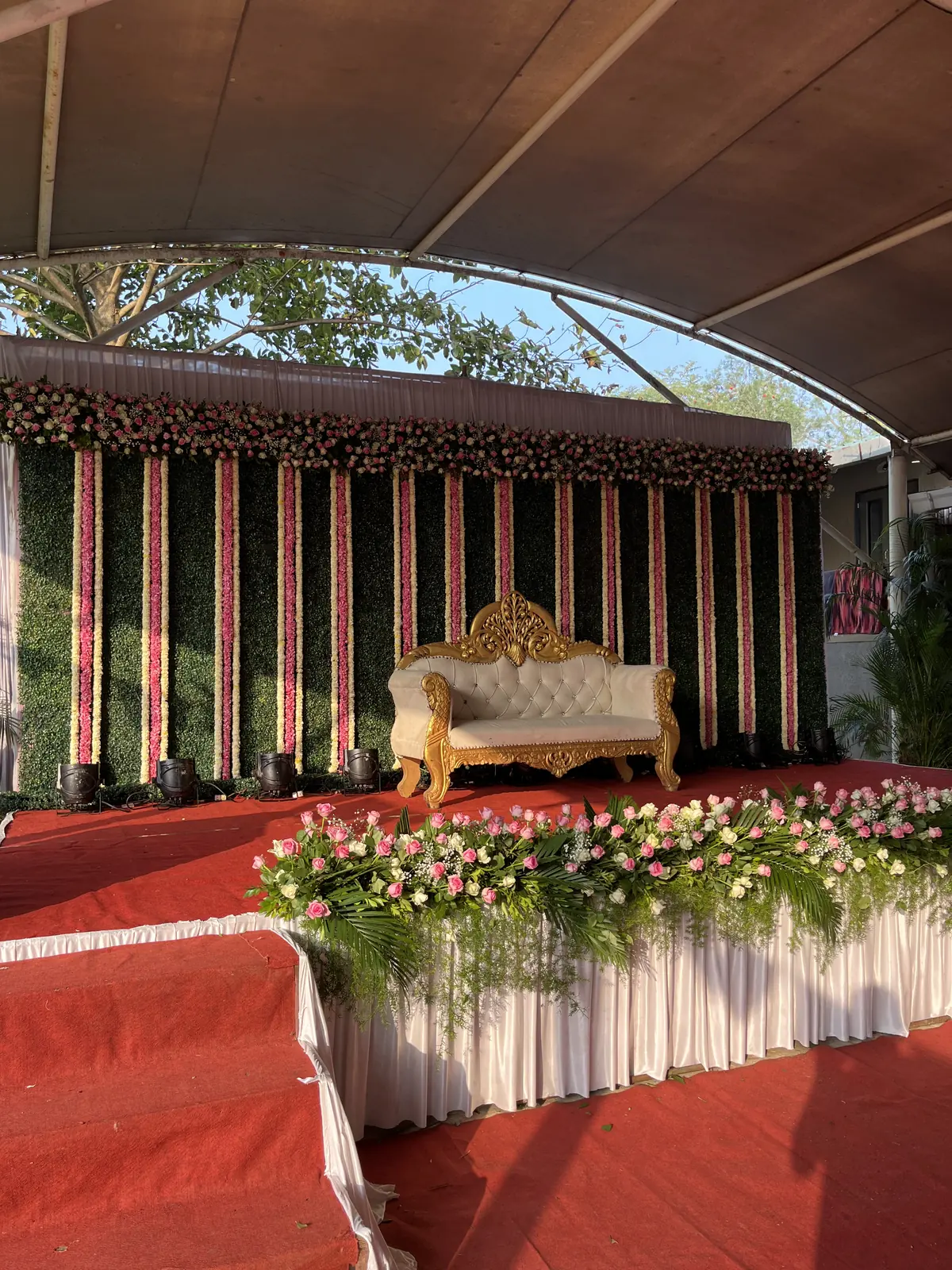 Reception stage with a red carpet and flowers
