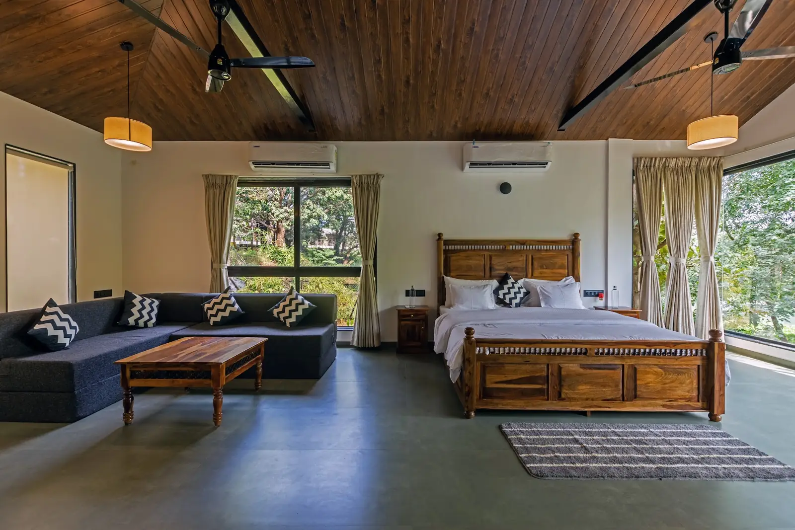 Riverside Suite bedroom with tall windows onto the trees