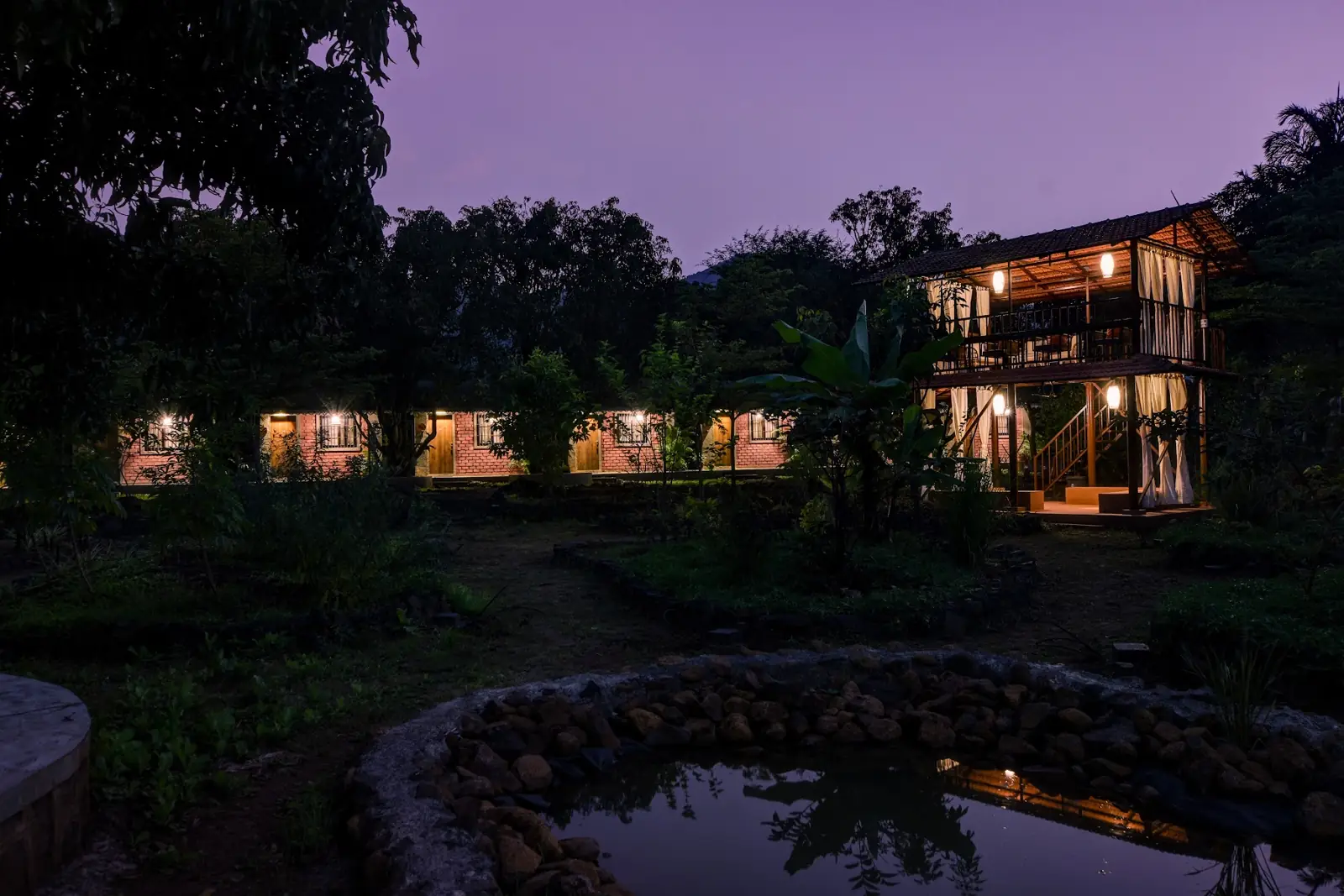 Cottages lit at dusk beside the pond