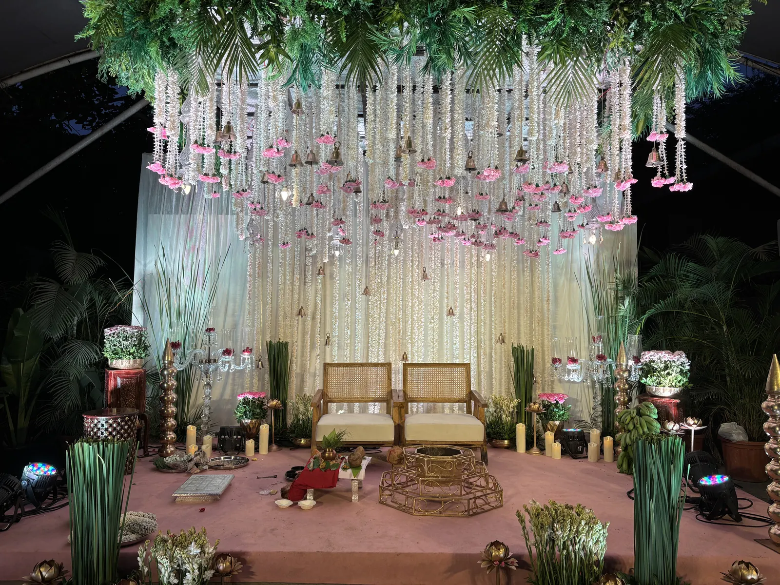 Mandap with hanging flower strings, lit at night